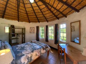 a bedroom with a bed and a table and windows at Sani Lodge & Cottages in Sani Pass +103 photos