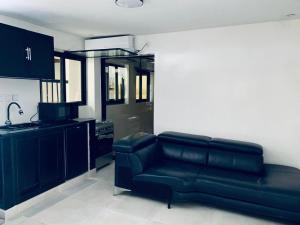 a living room with a couch and a kitchen at Résidence kali in Guediawaye
