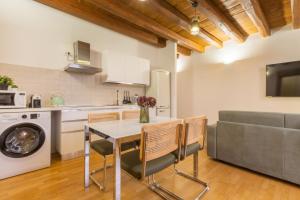 a kitchen and living room with a table and chairs at Martini Castello Boutique Apartments - Historic Center & Lift in Cagliari