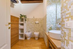 a bathroom with a tub and a toilet and a sink at Martini Castello Boutique Apartments - Historic Center & Lift in Cagliari