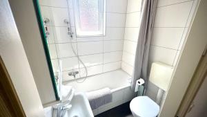 a white bathroom with a shower and a toilet at Between City&Nature in Herzogenrath