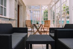 ein Raum mit Stühlen und einem Tisch und Fenstern in der Unterkunft Bella y cálida cerca de Vigo by CABANA Rentals in Vigo