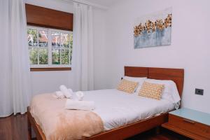 ein Schlafzimmer mit einem Bett mit Handtüchern darauf in der Unterkunft Bella y cálida cerca de Vigo by CABANA Rentals in Vigo