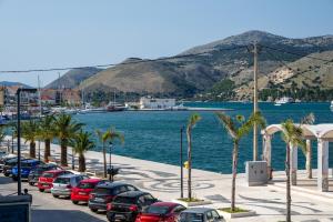 Una fila de autos estacionados en un estacionamiento junto al agua en Centro Y Mar I, en Argostoli