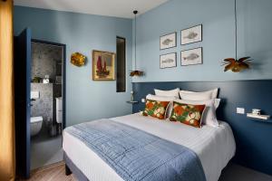 a bedroom with blue walls and a bed with pillows at La Maison du Traict Chambre d'hôtes in Le Croisic