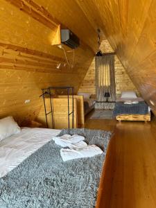 łóżko w drewnianym pokoju z ręcznikami w obiekcie Sunny Cottage w mieście Martwili