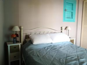a bedroom with a bed and two tables with lamps at The Iconpainter Kalamaki Villa in Kómboi