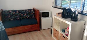 a living room with a couch and a microwave at Entre ciel et Sèvre in Treize-Vents