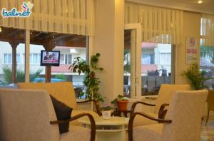 a lobby with chairs and a table and a tv at Efsanem Hotel in Ayvalık