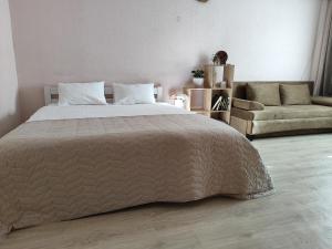 a bedroom with a large bed and a couch at Однокімнатна на Троєщині in Kyiv