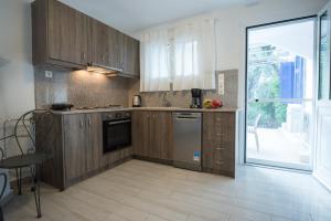 a kitchen with wooden cabinets and a large window at Velanidia House in Lygia