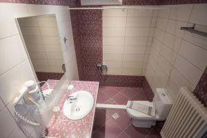 a small bathroom with a sink and a toilet at Velanidia House in Lygia