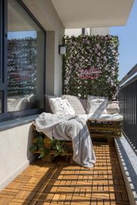 a balcony with a bed and a large window at Mountain and City View with Underground Parking in Braşov