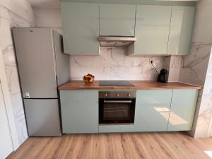 a kitchen with white cabinets and a refrigerator at El Surtidor in Anna