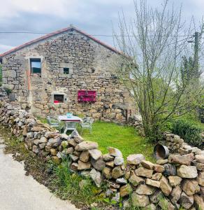 a stone house with a table and a stone wall at Casa Cueto in Sel de la Carrera