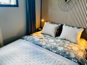 a bedroom with a bed with pillows on it at Färlevfjordens Glamping Brastad in Brastad