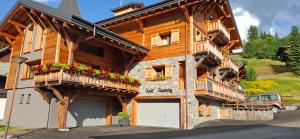 una gran casa de madera con flores en los balcones en CHALET CHARMING BED and BREAKFAST, en Les Gets 58 fotos más