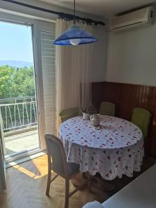 a table with chairs and a blue umbrella in a room at Anako in Novi Vinodolski