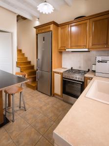 a kitchen with wooden cabinets and a stainless steel refrigerator at Villa Antonio in Romírion