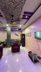 Una sala de estar con sofás y un televisor de pantalla plana. en The Aurelia Inn, en Sibsāgar