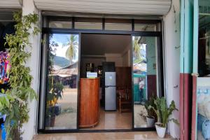 an open glass door of a store with a refrigerator at Kamalay Pension House Puerto Princesa in Nagpoyopoyo Island