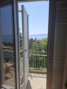 a door to a balcony with a view of the ocean at Anako in Novi Vinodolski