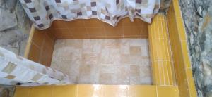 eine Dusche mit einer gelben Wanne mit einem karierten Duschvorhang in der Unterkunft Tranquilidad in San Cristóbal de las Casas