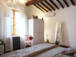 a bedroom with a bed and a chair and a window at Casal di Peppe B&B in Lorenzana