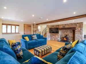 a living room with blue couches and a fireplace at Heathmoor in Yelverton