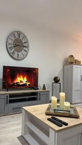 a living room with a clock and a fireplace at Maison moderne pour 6 personnes in Laferté-sur-Aube