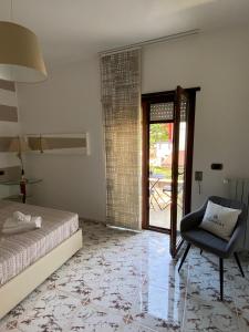 a bedroom with a bed and a chair and a sliding glass door at B&B Le Giadali in Praia a Mare