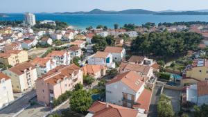 an aerial view of a town with houses and the water at Rooms & Apartments Blue Beach in Vodice