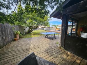 una terraza de madera con una mesa de picnic. en Maison Claouey, en Lège-Cap-Ferret