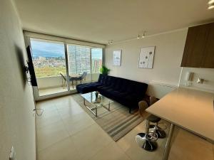 una sala de estar con un sofá y una mesa en Nuevo y cómodo en Costa de Montemar, en Concón