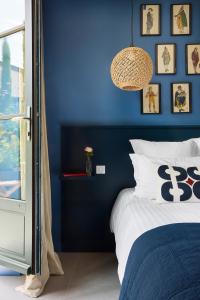 ein blaues Schlafzimmer mit einem Bett und einer blauen Wand in der Unterkunft La Maison du Traict Chambres d'hôtes in Le Croisic