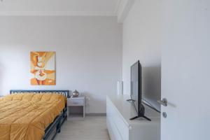 ein Schlafzimmer mit einem Bett und einem Flachbildfernseher in der Unterkunft Casa ariel in Lecce