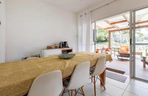 ein Schlafzimmer mit einem großen Bett und weißen Stühlen in der Unterkunft Melhor casa Praia na Reserva do Sahy in Mangaratiba