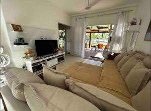 ein Wohnzimmer mit Sofa und Fernseher in der Unterkunft Melhor casa Praia na Reserva do Sahy in Mangaratiba