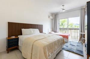 ein Schlafzimmer mit großem Bett und Balkon in der Unterkunft Melhor casa Praia na Reserva do Sahy in Mangaratiba + 71 Fotos