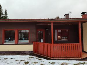 Una casa con un porche delantero rojo en la nieve. en Artjarvi Center Art Villa vacation house, en Artjärvi 10 fotos más