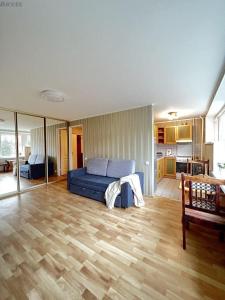 a living room with a blue bed and a kitchen at Сozy accommodation in Sillamäe