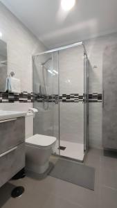 a bathroom with a shower and a toilet and a sink at Apartamento Los Corrales in Rota