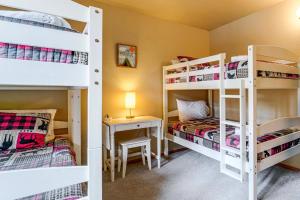 two bunk beds in a room with a desk and a bed at Home with Deck and Access to Tahoe Donner Amenities! in Truckee