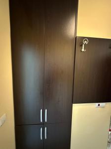 Un armario negro con una llave al lado de un refrigerador. en Студио до плажа Свети Влас, en Sveti Vlas