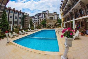 Una piscina en un patio con sillas y flores. en Студио до плажа Свети Влас, en Sveti Vlas