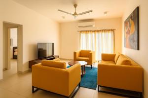 a living room with two couches and a tv at Fairway Galle Cozy 2BR Apartment Near Beach & City in Galle