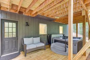 DadevilleにあるFamily-Friendly Dadeville Cabin with Hot Tub and Porchの家の中にあるホットタブ付きの部屋