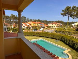 a view of a swimming pool from the balcony of a house at Casa Amarela - O seu Oásis na floresta in Praia de Mira