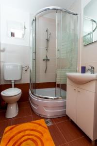 y baño con ducha, aseo y lavamanos. en Apartments Tomaš, en Trogir
