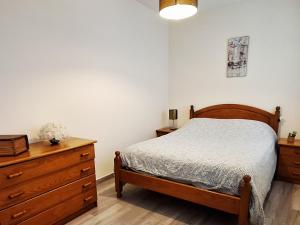 a bedroom with a bed and a wooden dresser at Palheiro do Fontenário in Funchal